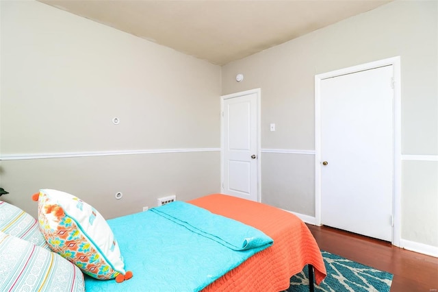 bedroom with dark hardwood / wood-style floors