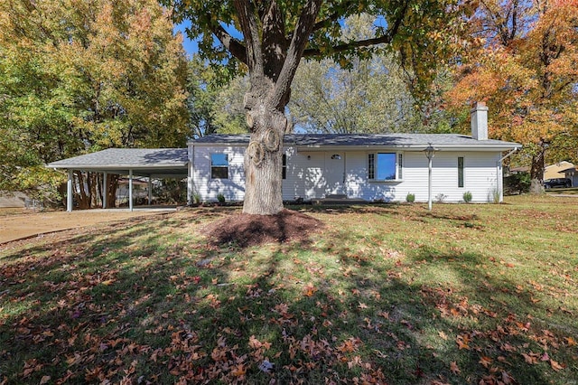 rear view of property with a carport and a lawn