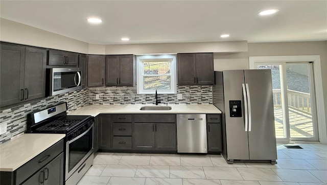 kitchen featuring decorative backsplash, sink, dark brown cabinets, and appliances with stainless steel finishes