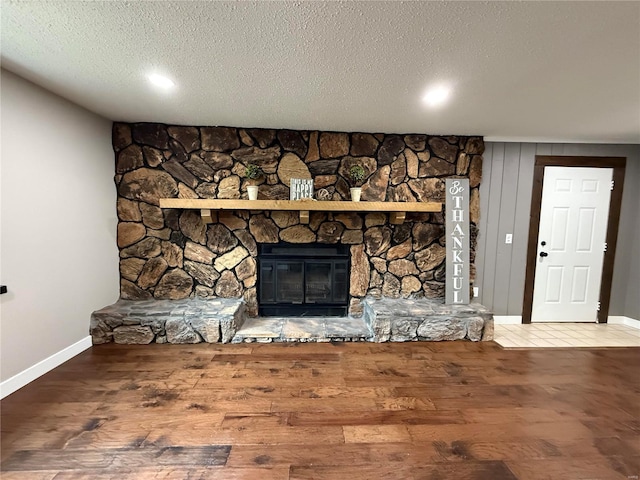 room details with a fireplace, hardwood / wood-style floors, and a textured ceiling