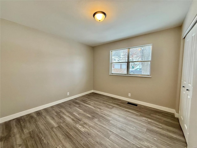 unfurnished bedroom featuring a closet and hardwood / wood-style floors