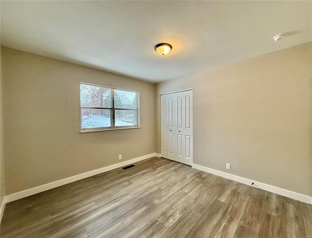 unfurnished bedroom featuring light wood-type flooring and a closet