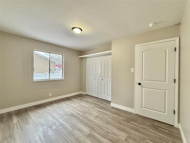 unfurnished bedroom with a closet and light hardwood / wood-style floors