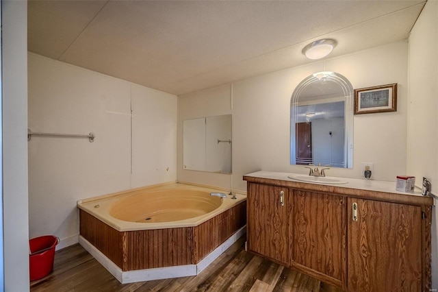 bathroom with vanity, a bath, and wood-type flooring