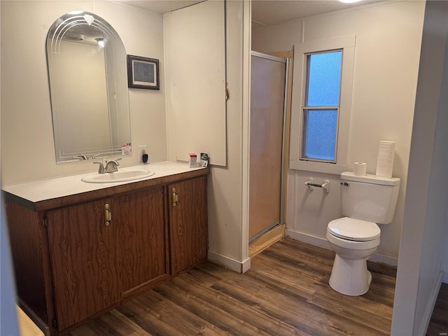 bathroom featuring vanity, a shower with shower door, toilet, and wood-type flooring