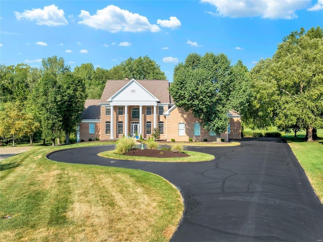 greek revival inspired property with a front yard