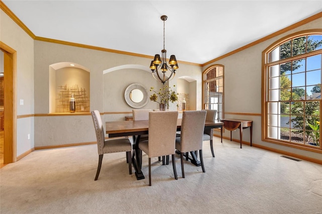 carpeted dining area with a notable chandelier and crown molding