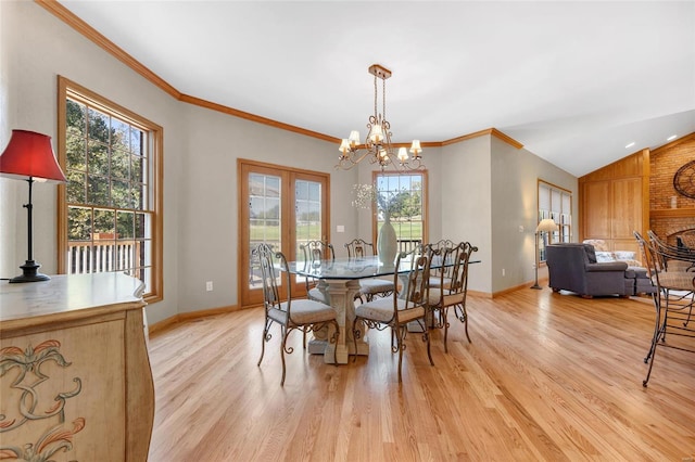 dining space featuring vaulted ceiling, an inviting chandelier, light hardwood / wood-style floors, and crown molding