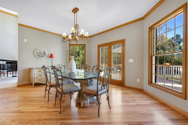 dining room with french doors, a chandelier, crown molding, and light wood-type flooring