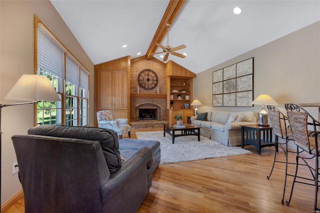 living room with a fireplace, lofted ceiling with beams, ceiling fan, and light hardwood / wood-style flooring