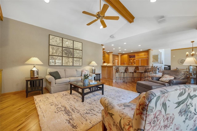 living room featuring ceiling fan with notable chandelier, light hardwood / wood-style floors, and vaulted ceiling with beams