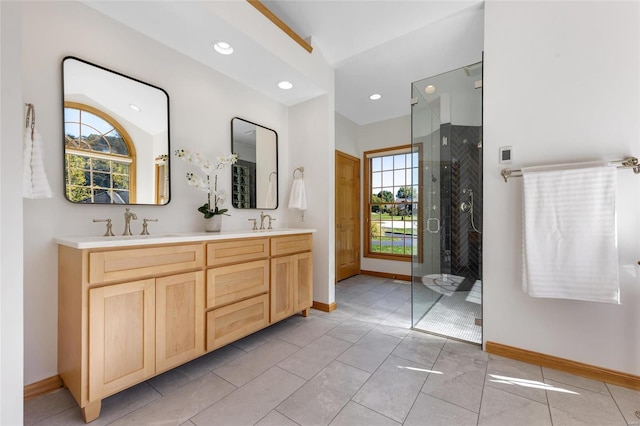 bathroom featuring a healthy amount of sunlight, walk in shower, tile patterned floors, and vanity