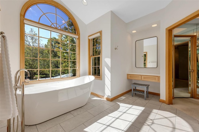 bathroom featuring a bathtub, vaulted ceiling, and tile patterned floors