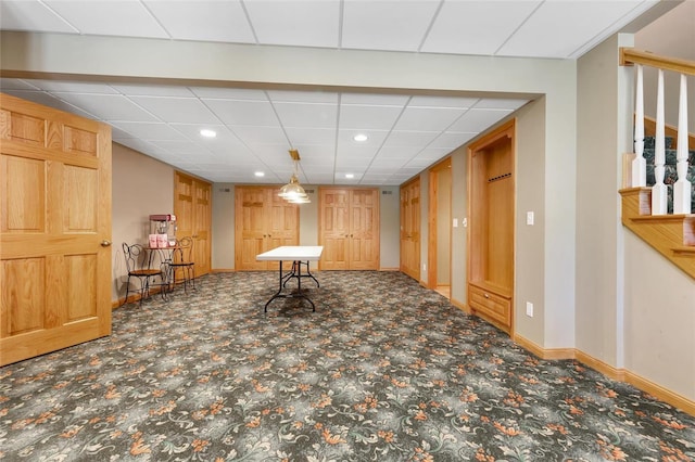 interior space with carpet floors and a paneled ceiling