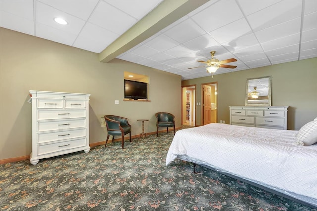 carpeted bedroom with a drop ceiling, ceiling fan, and beam ceiling