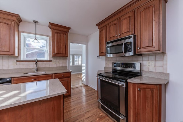 kitchen featuring a healthy amount of sunlight, sink, light wood-type flooring, and stainless steel appliances