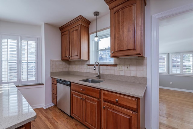 kitchen with sink, stainless steel dishwasher, plenty of natural light, and light hardwood / wood-style flooring