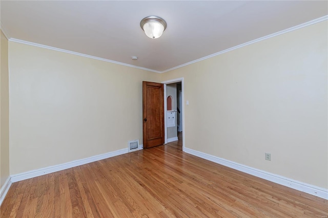 unfurnished room with light wood-type flooring and crown molding