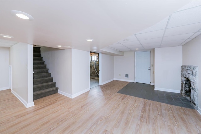 basement with hardwood / wood-style flooring and a paneled ceiling