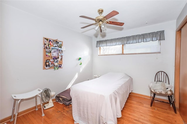 bedroom with a closet, light hardwood / wood-style flooring, and ceiling fan