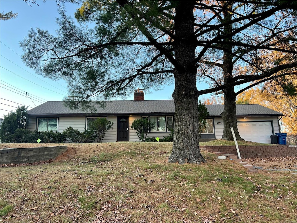 ranch-style house featuring a front yard and a garage