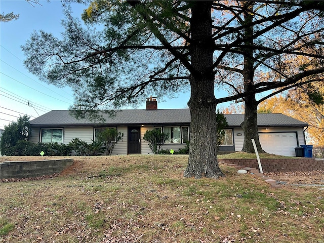 ranch-style house featuring a front yard and a garage