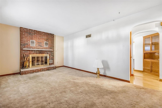 unfurnished living room featuring carpet flooring and a fireplace