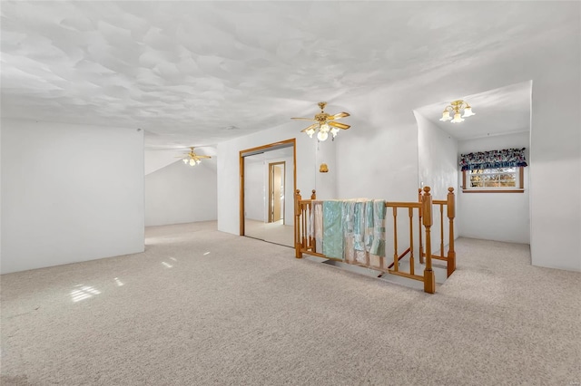 empty room with light carpet and ceiling fan with notable chandelier