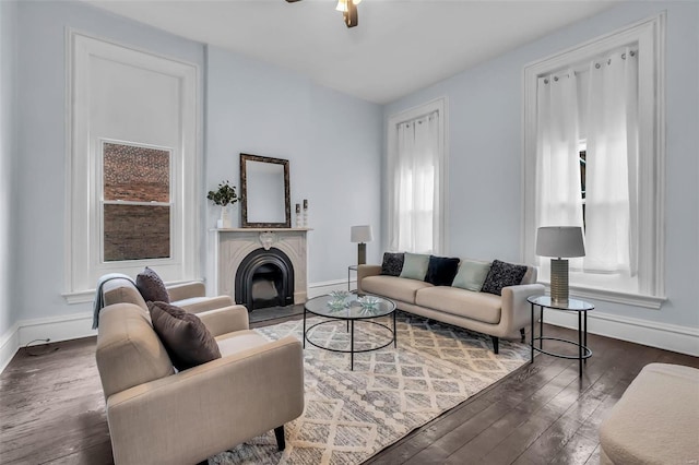 living room featuring ceiling fan, a healthy amount of sunlight, and dark wood-type flooring