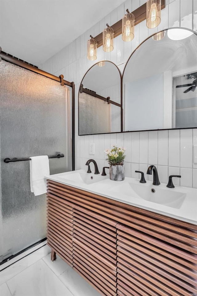 bathroom with decorative backsplash, a shower with door, tile walls, and vanity