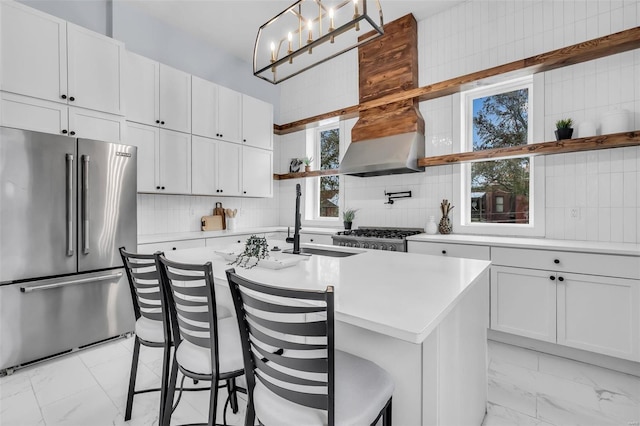 kitchen with a breakfast bar area, white cabinetry, an island with sink, and stainless steel appliances