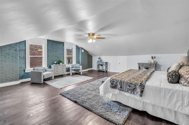 bedroom with ceiling fan, brick wall, vaulted ceiling, and hardwood / wood-style flooring