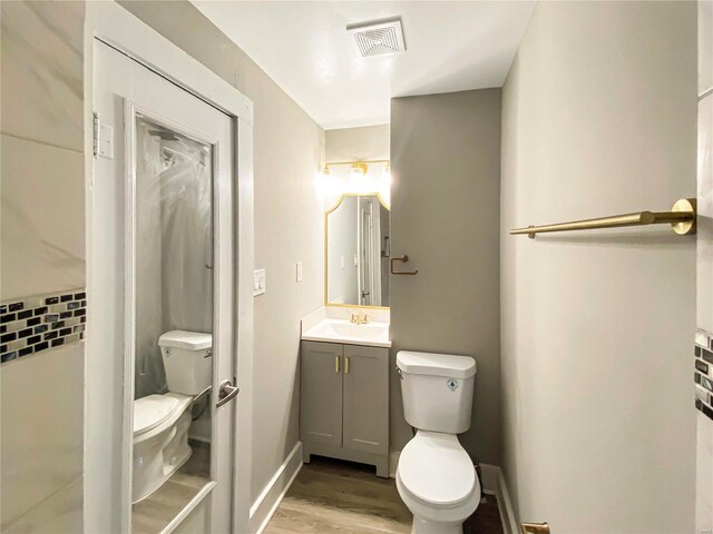 bathroom with decorative backsplash, hardwood / wood-style floors, vanity, and toilet