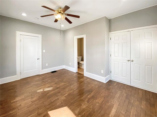 unfurnished bedroom with dark hardwood / wood-style flooring, ensuite bathroom, and ceiling fan