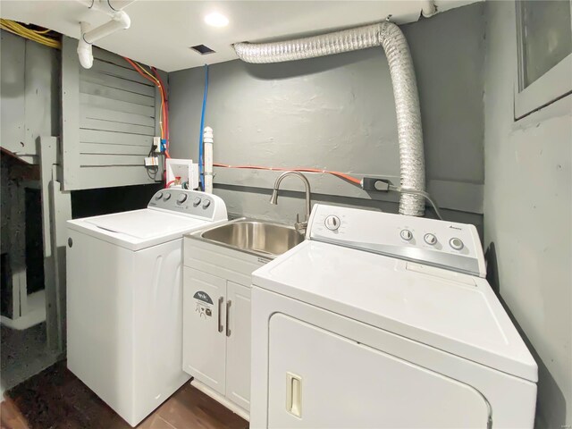 clothes washing area featuring cabinets, dark wood-type flooring, sink, and washing machine and clothes dryer