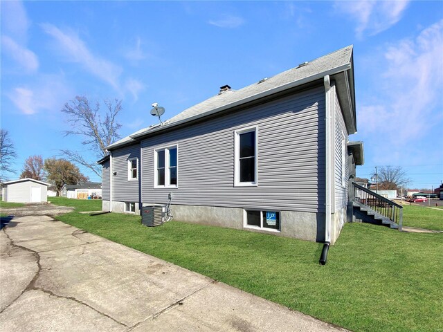 view of side of home featuring a lawn and cooling unit