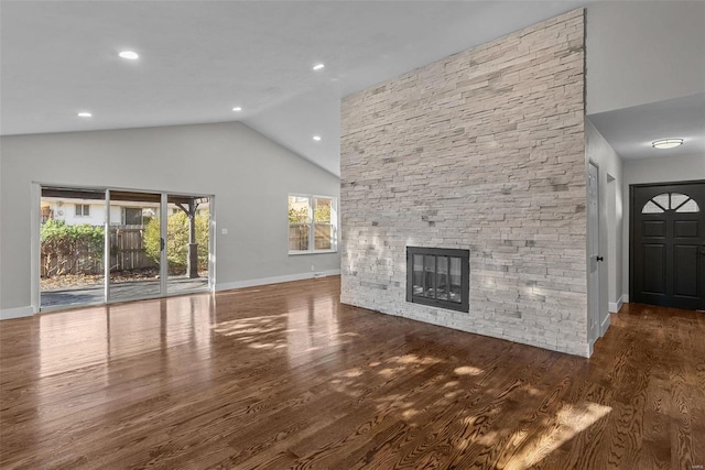 unfurnished living room featuring a fireplace, dark hardwood / wood-style flooring, high vaulted ceiling, and a healthy amount of sunlight