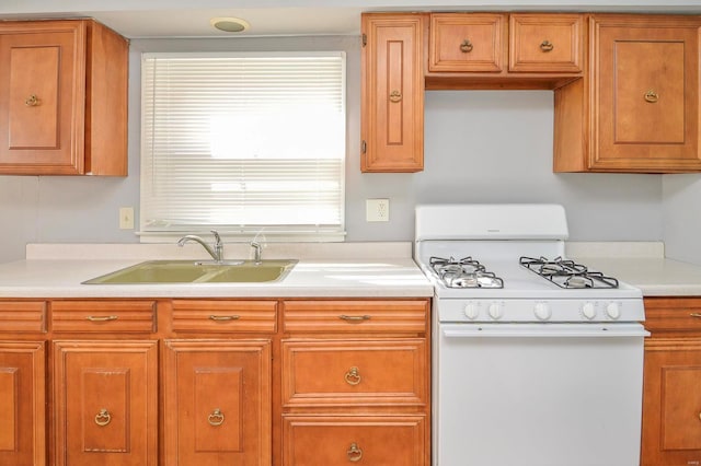 kitchen featuring white gas stove and sink