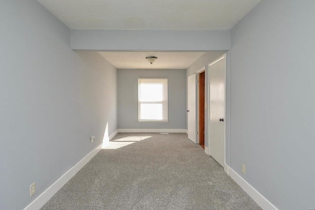 spare room with light colored carpet and a textured ceiling