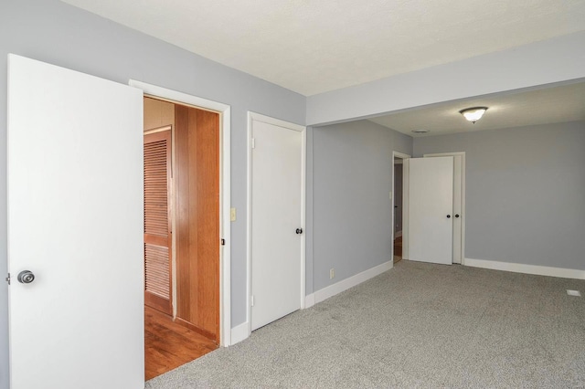 interior space featuring light carpet, a textured ceiling, and a closet