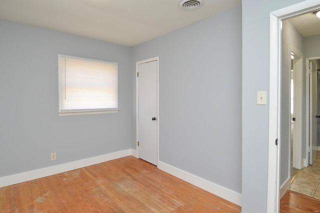 empty room with light hardwood / wood-style flooring