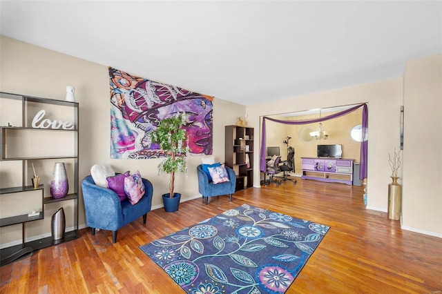 sitting room with wood-type flooring and a chandelier