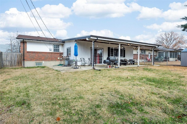 rear view of property with a patio and a lawn