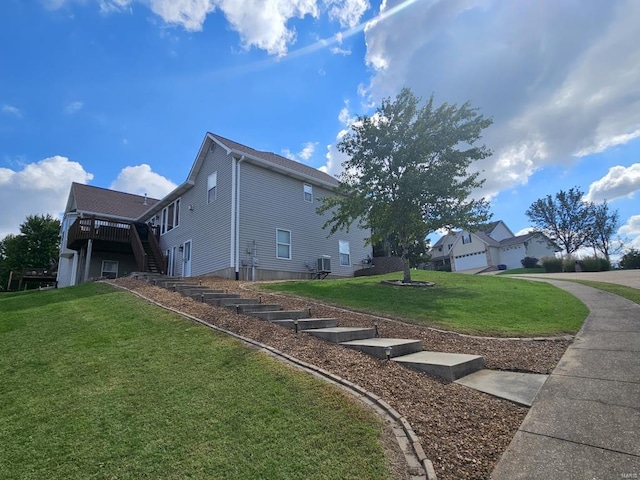 view of home's exterior featuring a yard, a deck, and a garage