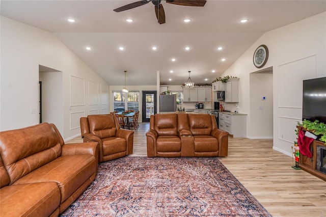 living room with ceiling fan, high vaulted ceiling, and light hardwood / wood-style floors