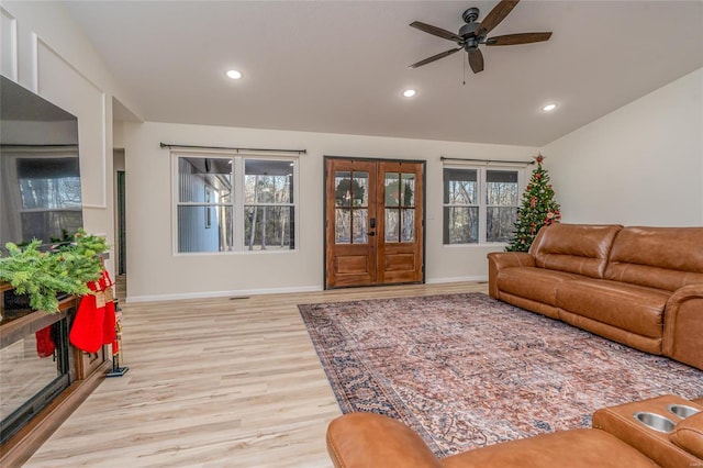 living room with ceiling fan, a healthy amount of sunlight, light wood-type flooring, and french doors