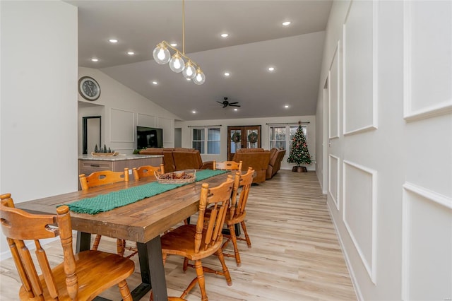 dining room with light hardwood / wood-style floors, high vaulted ceiling, and ceiling fan