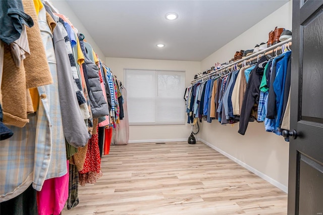 walk in closet with light hardwood / wood-style flooring