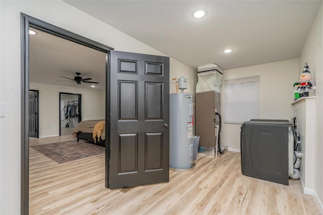 laundry area featuring ceiling fan, light hardwood / wood-style flooring, washer / clothes dryer, and water heater