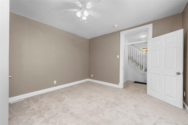 empty room featuring visible vents, baseboards, a ceiling fan, and light colored carpet